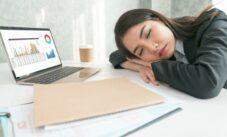 Overworked And Tired Businesswoman Sleeping Over A Laptop In A Desk At Work In Her Office