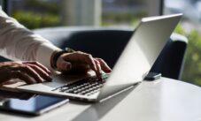 Man Working With Laptop Keyboard And Digital Tablet In Sunny Office, Business And Technology Concept. Close Up